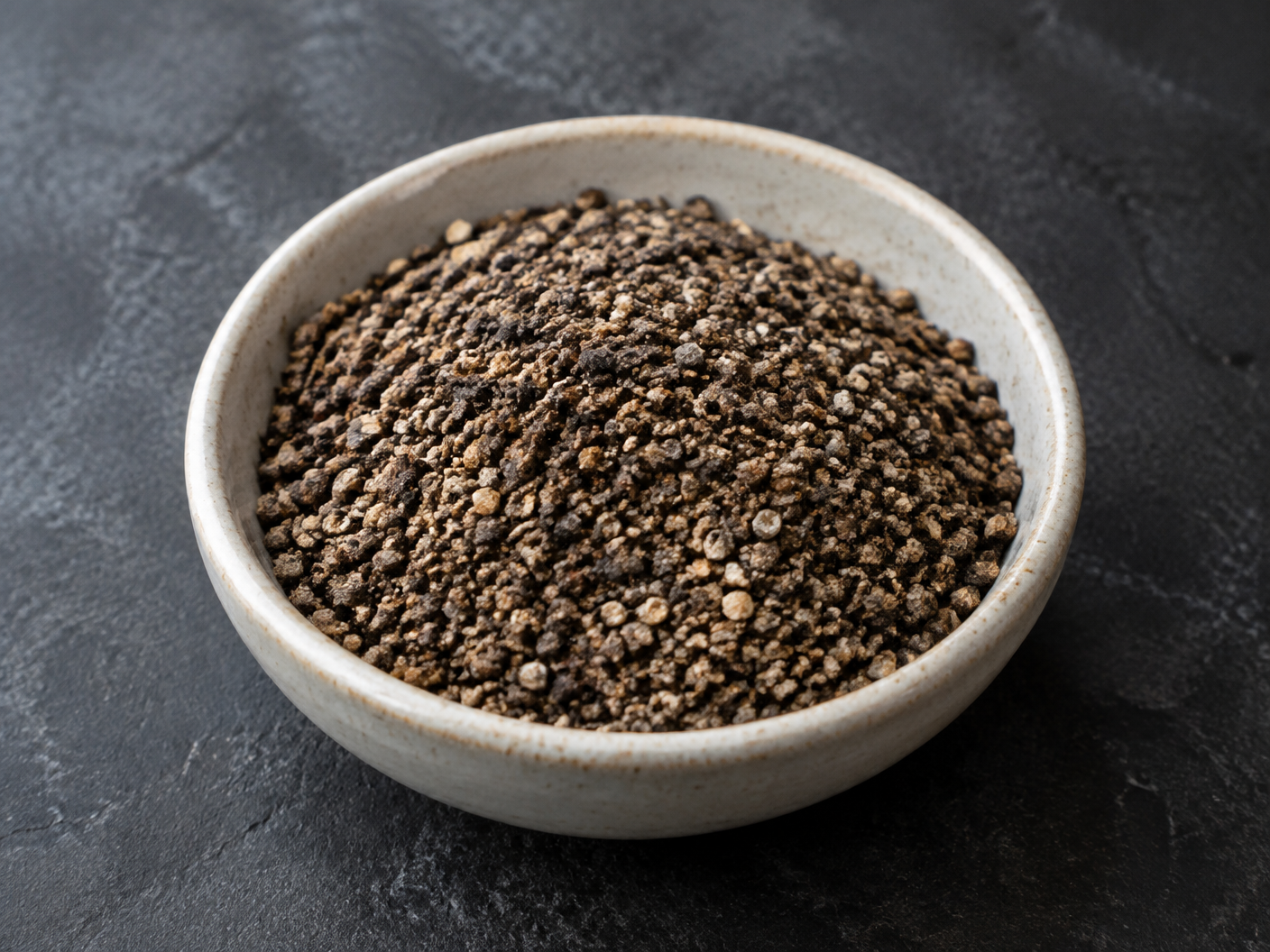 Coarsely ground black pepper in a ceramic bowl